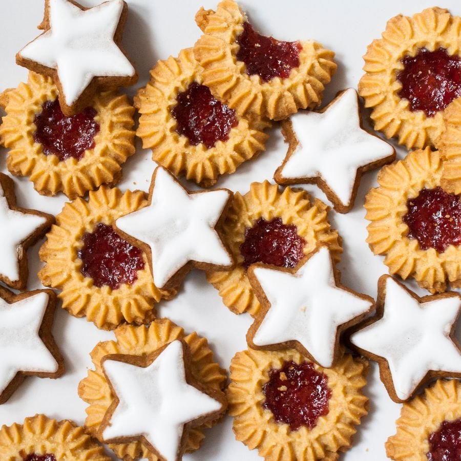 Jam-filled linzer cookies and iced star cookies seen from above