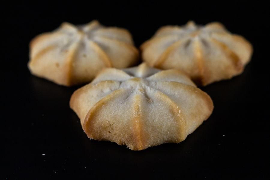 Piped butter cookies on a dark surface